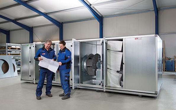 Gerätegehäuse mit zwei Monteuren im Vordergrund